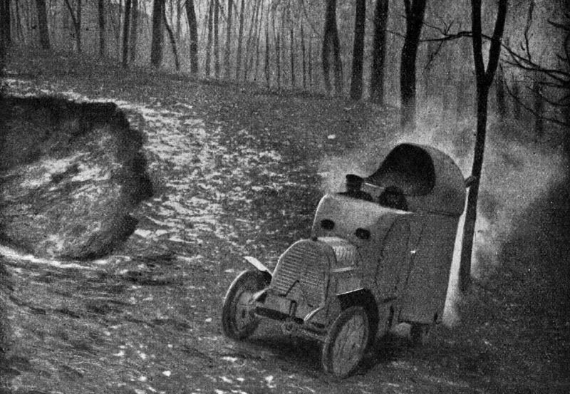 zobrazit detail historického snímku: Válečný automobil za jízdy lesem.
