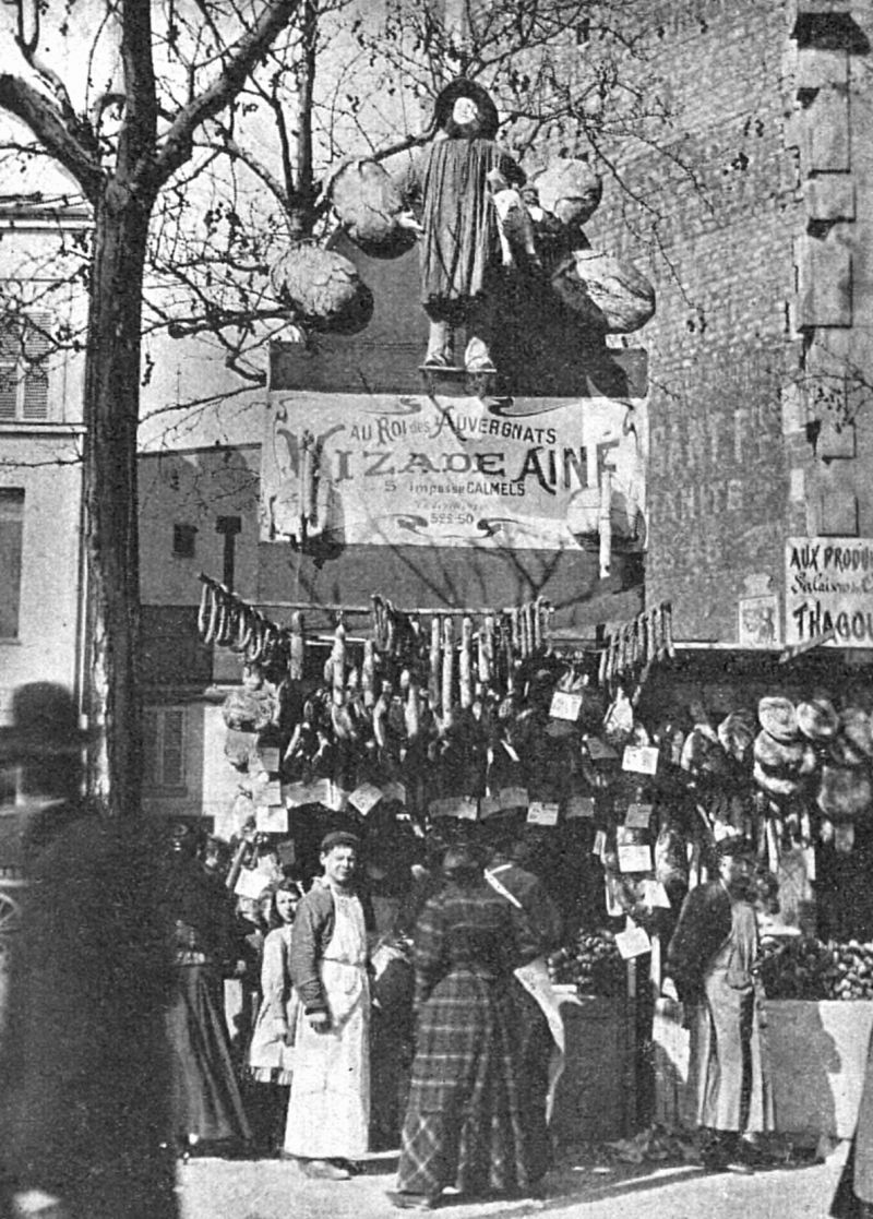 zobrazit detail historického snímku: Pařížský trh šunkový.  Krám s reklamou obrovskými salámy.